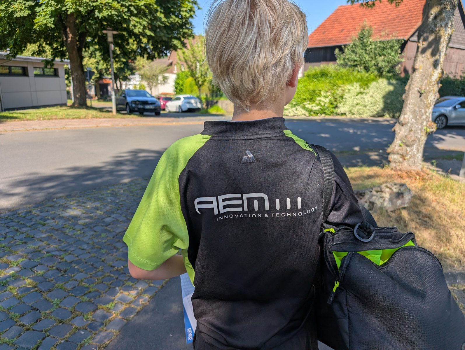 Rückansicht eines Spielers im grünen JOOLA-Trikot mit dem Schriftzug des Sponsors AEM auf dem Rücken.